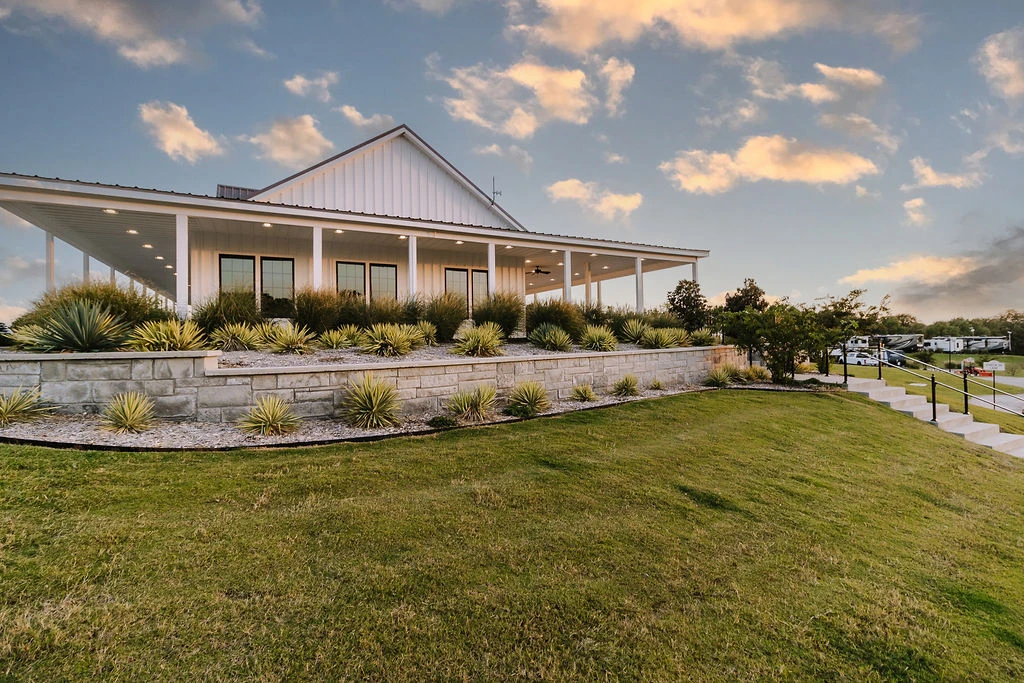 Clubhouse on the hill at dusk with a soft glow — the heart of the community where neighbors gather at Sugar Hill RV Resort.