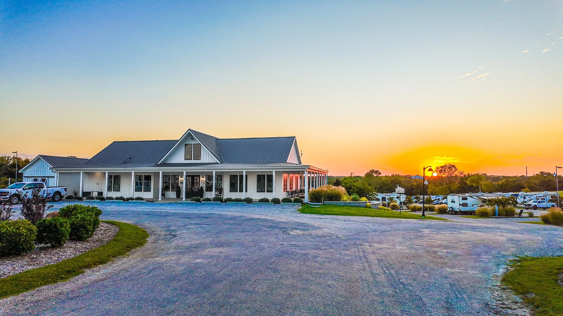 Golden-hour light across the Sugar Hill campus — manicured grounds and buildings in a sunset glow over Anna, Texas.